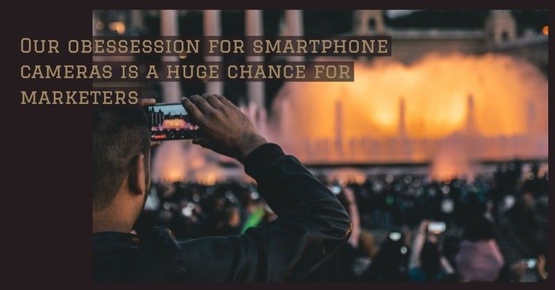 Ein Mann filmt ein Konzert oder eine Theateraufführung mit seinem Smartphone.