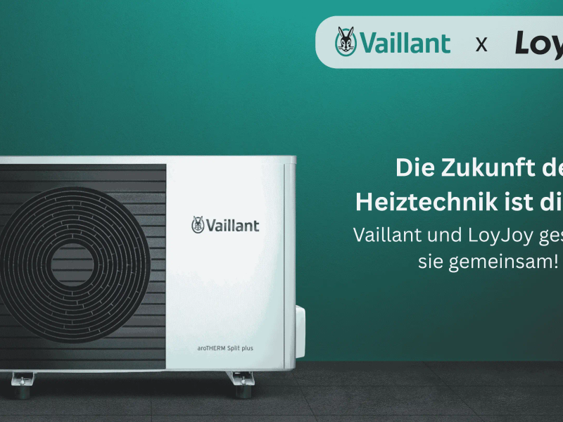 Das Bild zeigt eine moderne Wärmepumpe von Vaillant vor grünem Hintergrund mit dem Text: 'Die Zukunft der Heiztechnik ist digital: Vaillant und LoyJoy gestalten sie gemeinsam!'.
